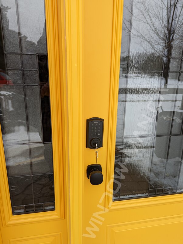 yellow steel door with sidelight and 3/4 santa fe stained glass, smart lock - detailed close up